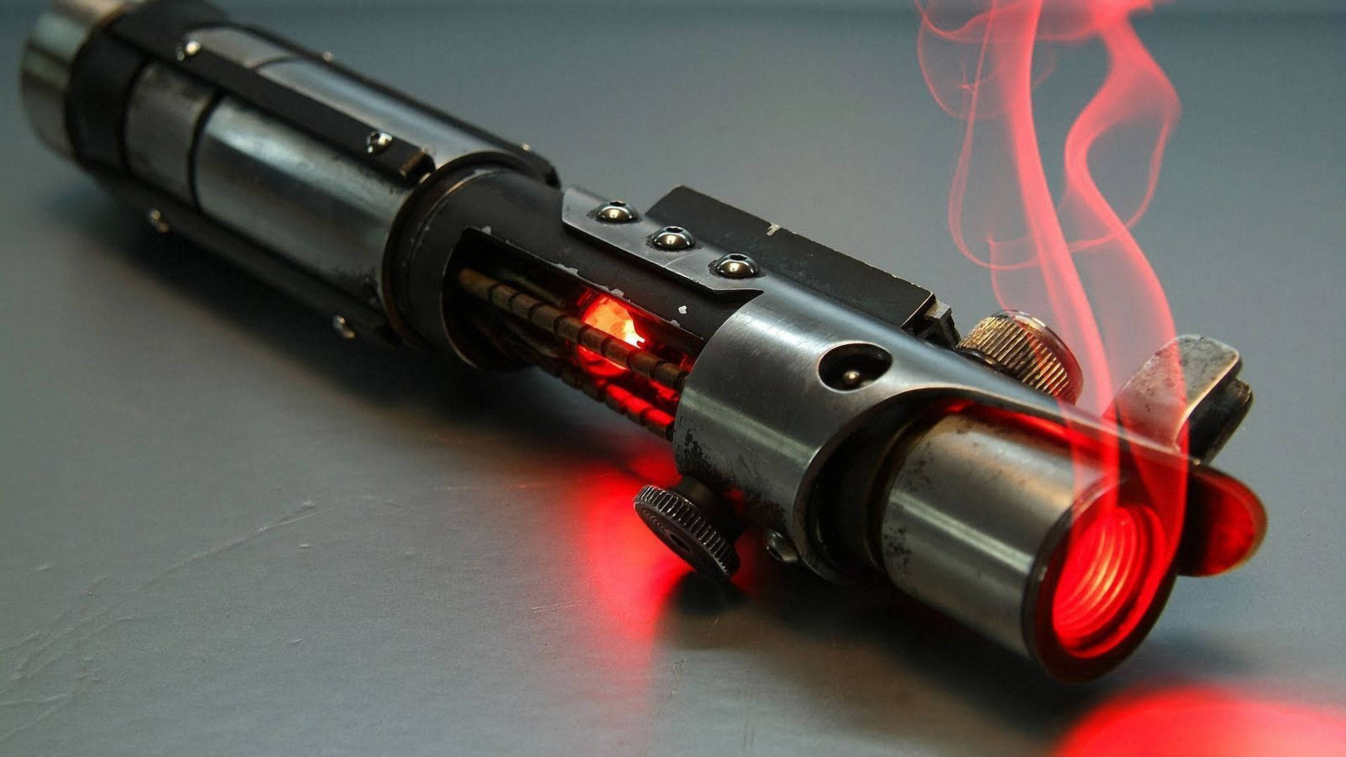 Unleash your inner Sith with this iconic red lightsaber Wallpaper