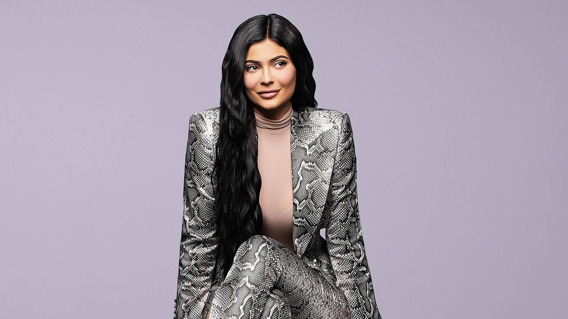 Sitting Kylie Jenner In Snakeskin Suit Wallpaper