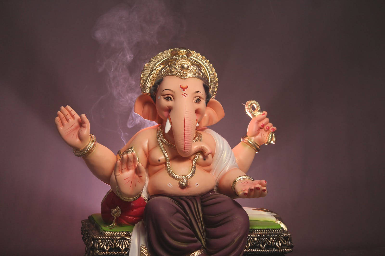 Download Sitting Vinayaka With Four Hands Wallpaper | Wallpapers.com