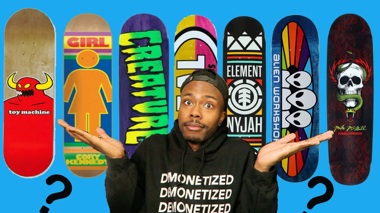 A Man Is Holding A Skateboard With Different Designs Wallpaper