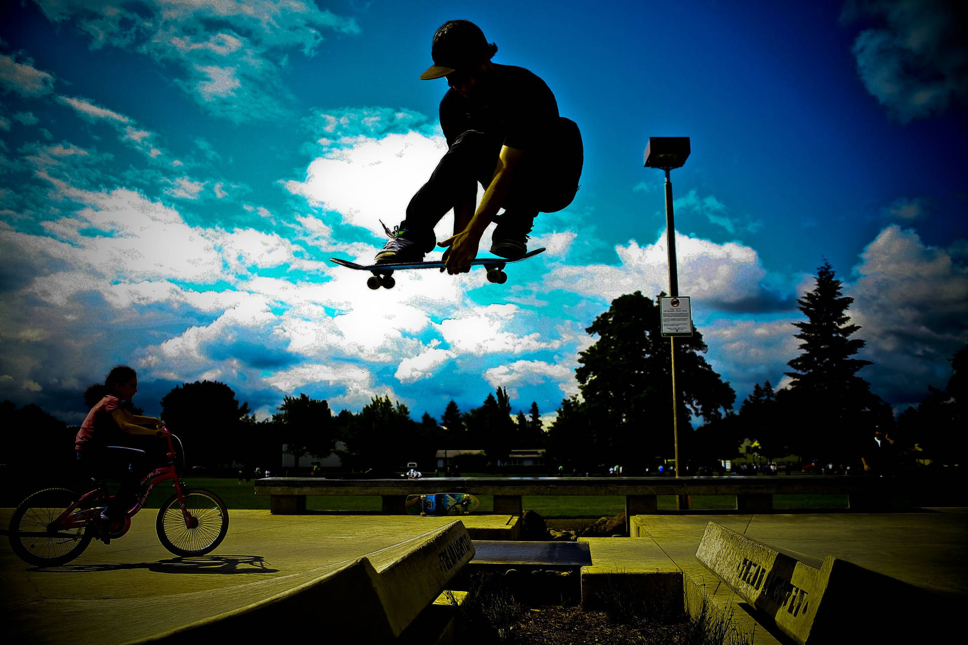 Skateboard enthusiast performing tricks in silhouette Wallpaper