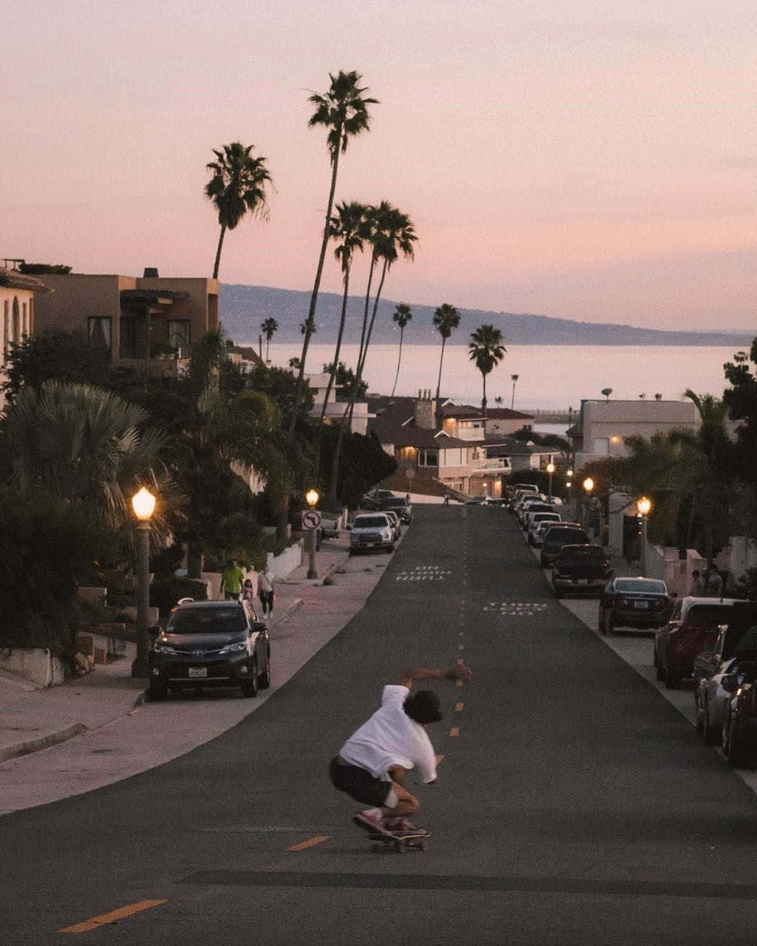 A Skateboarder Is Riding Down A Street