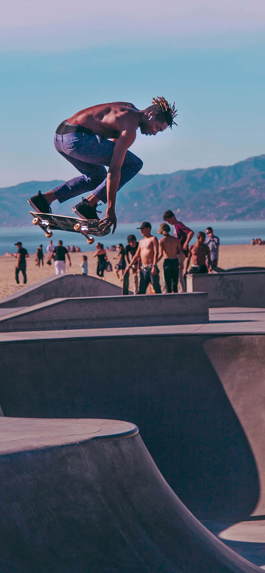 En mand udfører et trick på en skateboard. Wallpaper