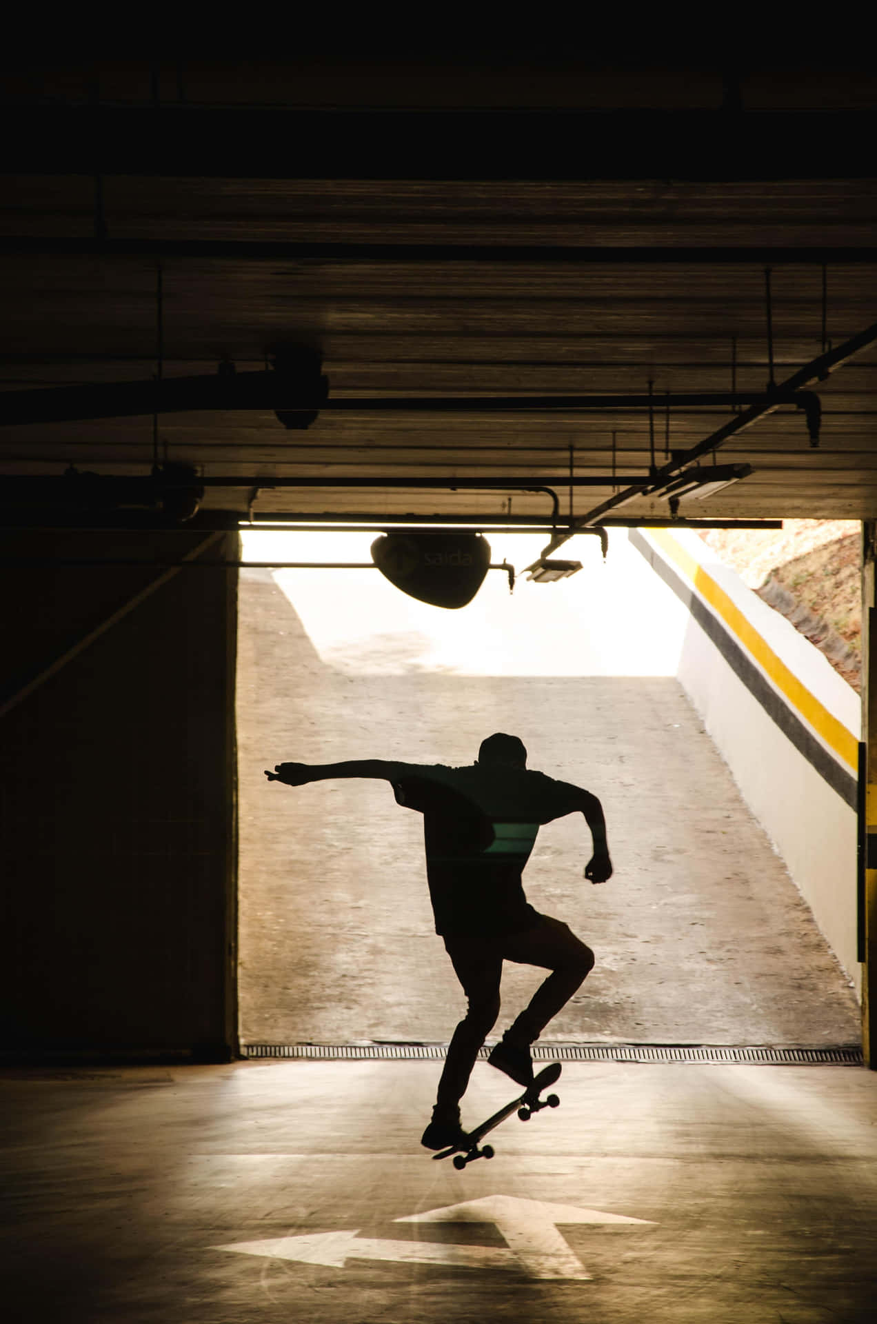An adventurous street skater making a daring jump over an obstacle Wallpaper