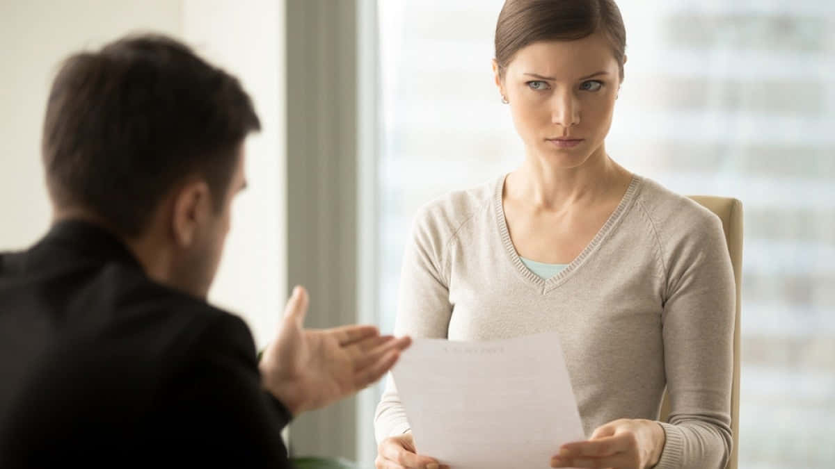 Skeptical Woman Evaluating Document Wallpaper