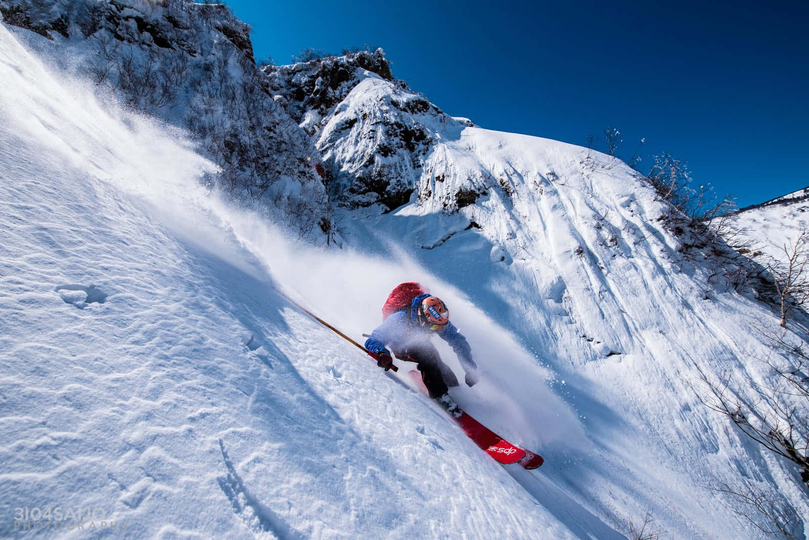A Skier Is Going Down A Snow Covered Mountain Wallpaper