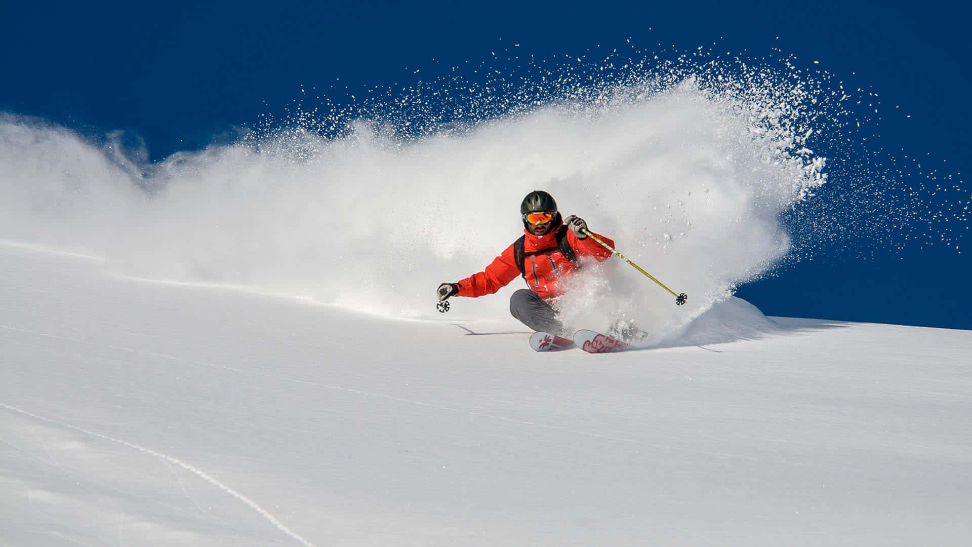 A skier carving down a pristine snowy slope