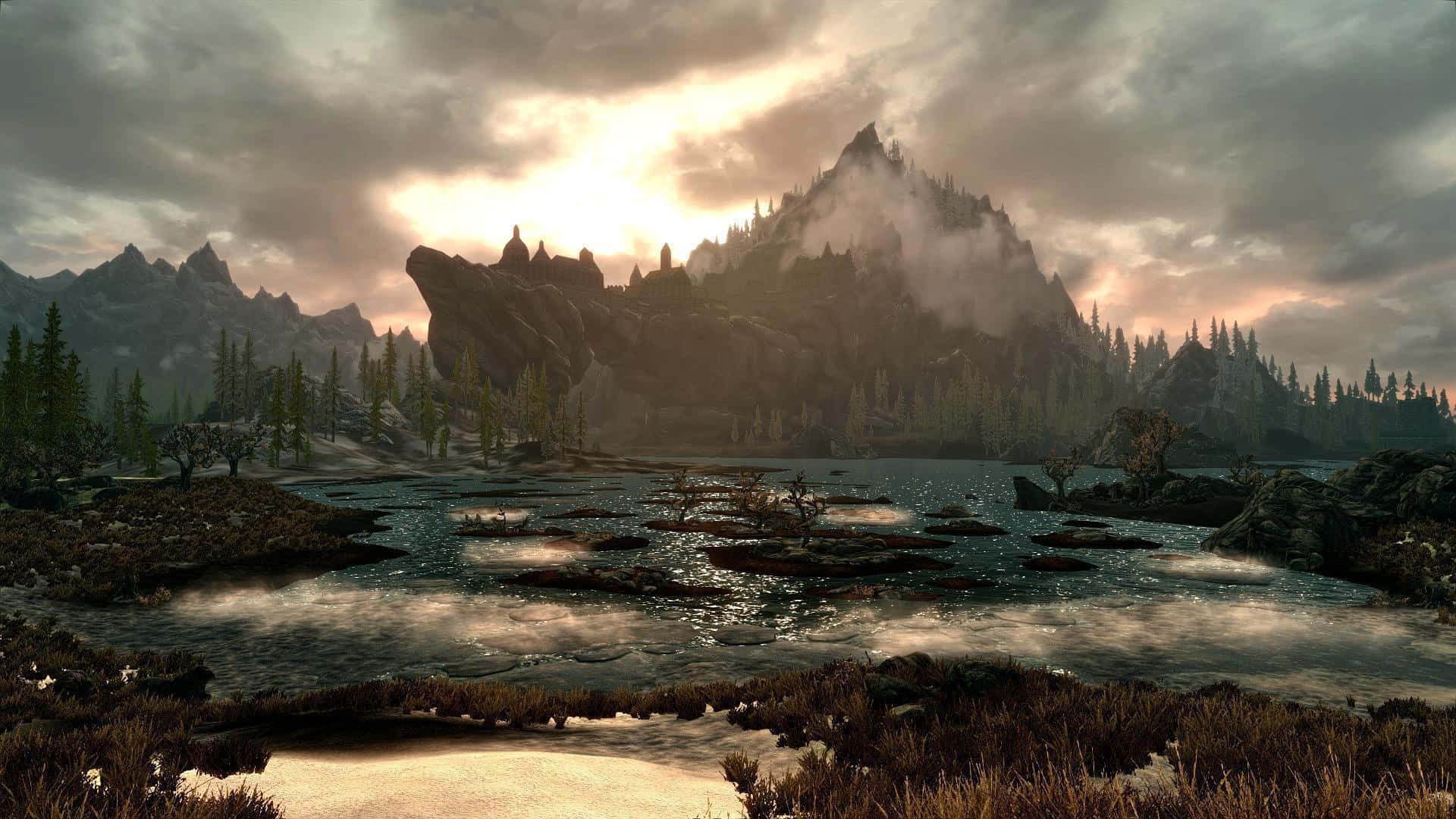 Majestic mountains and serene river in the stunning world of Skyrim Wallpaper