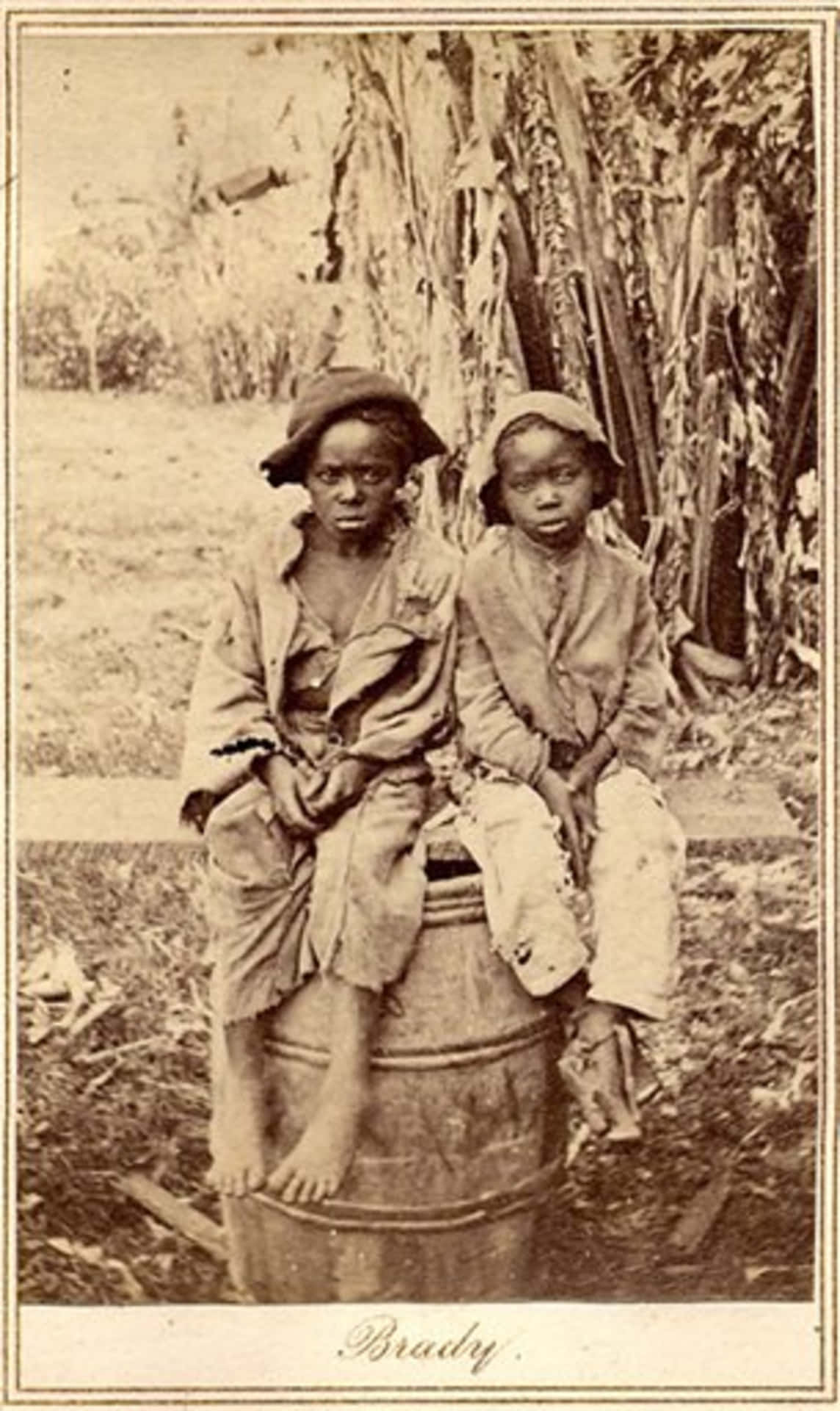 Two Boys Sitting On A Barrel