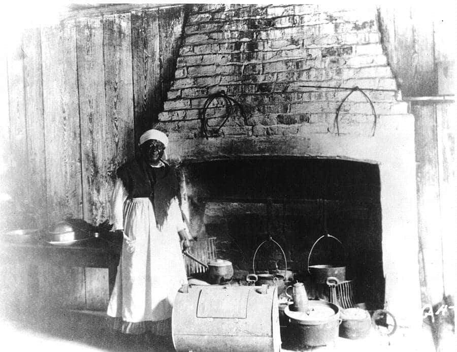 A Woman In A Kitchen With Pots And Pans