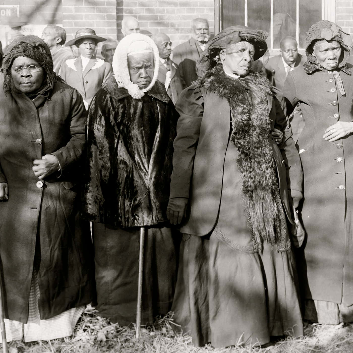 A Group Of Women Standing In Front Of A Brick Building