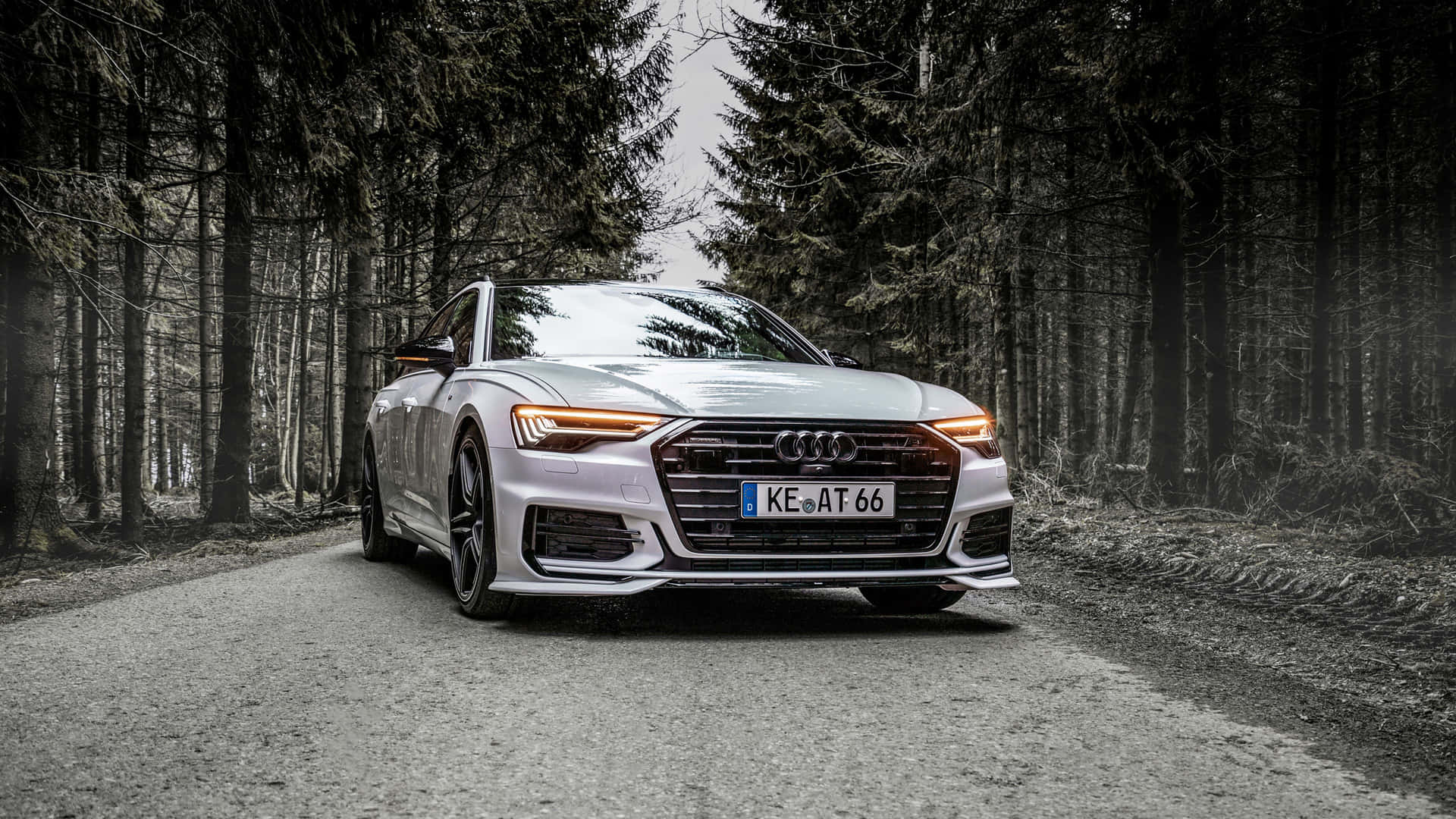 Sleek And Sophisticated Audi A6 Cruising Down A Beautiful Swept Road. Wallpaper
