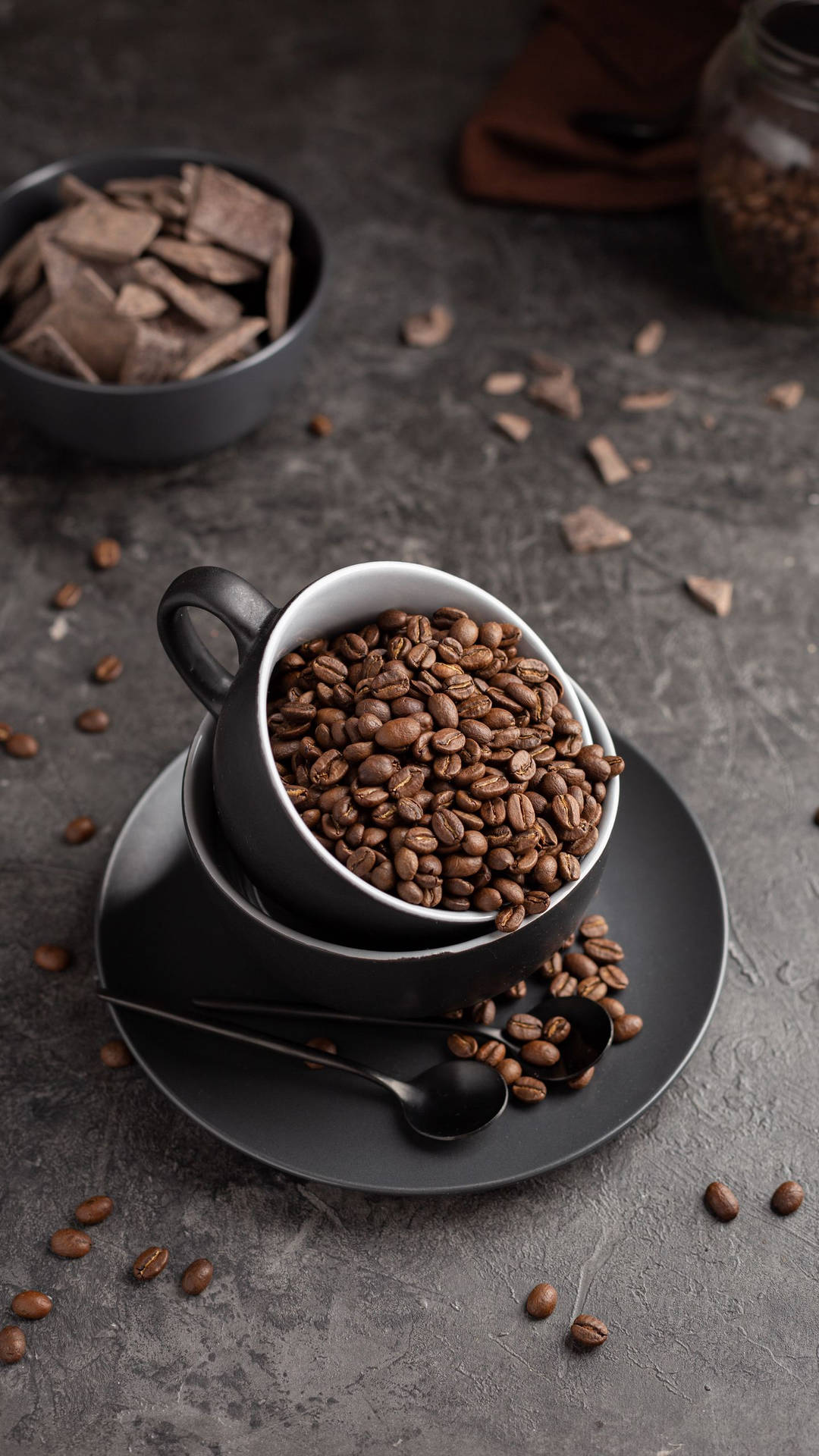 Sleek Black Cup Full Of Coffee Beans Background
