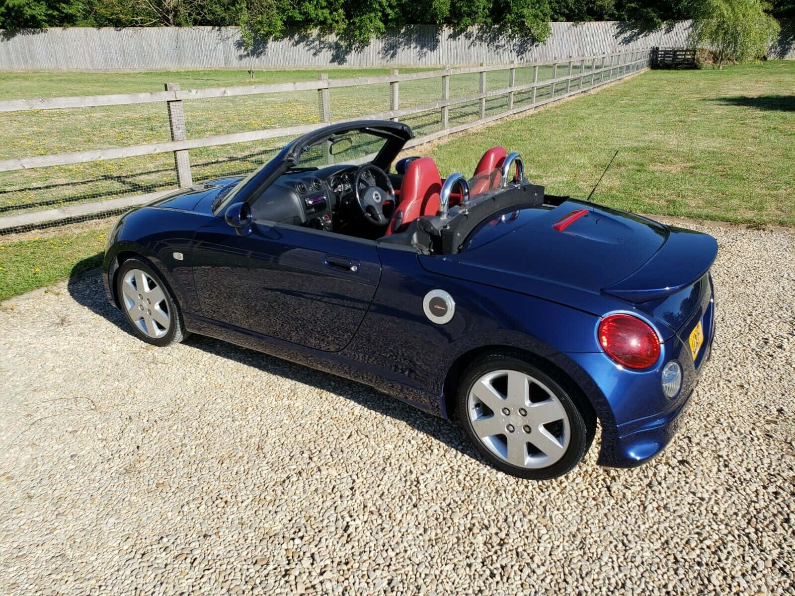 Sleek Daihatsu Copen Sports Car Parked On The Street Wallpaper