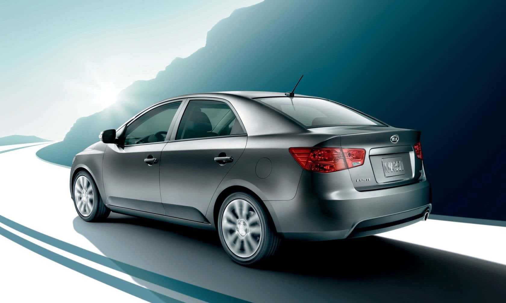 Sleek Kia Forte Sedan Cruising On The Road Wallpaper