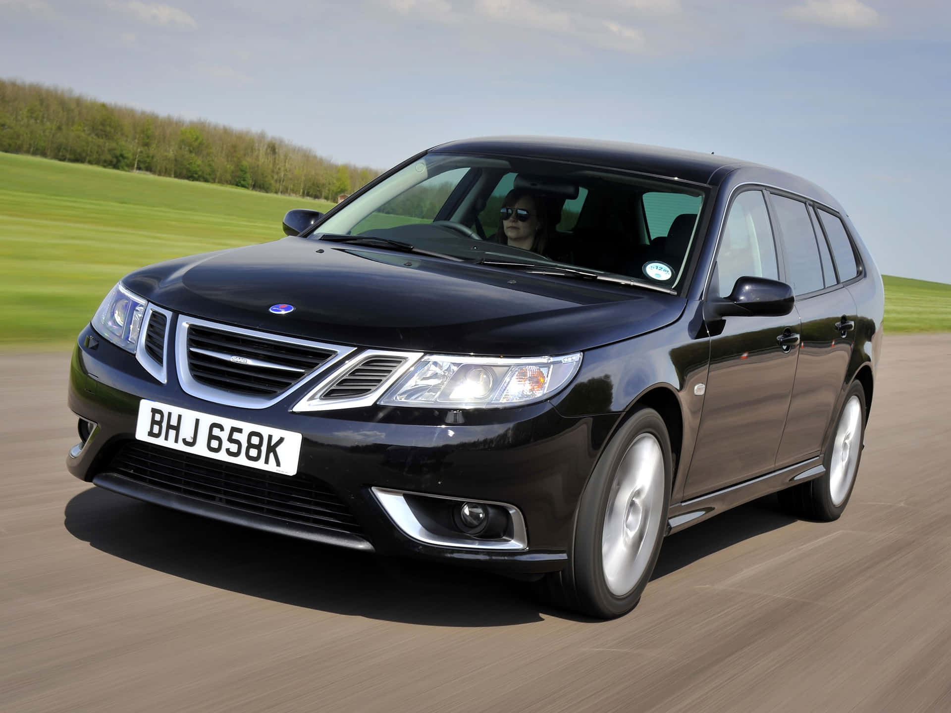 Sleek Saab 9-3 Parked On Evening Cityscape Wallpaper