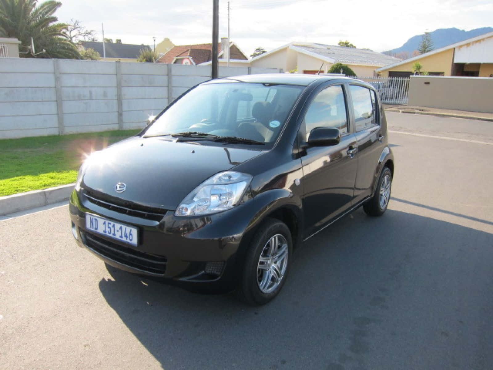 Sleek Silver Daihatsu Sirion Under A Clear Open Sky Wallpaper