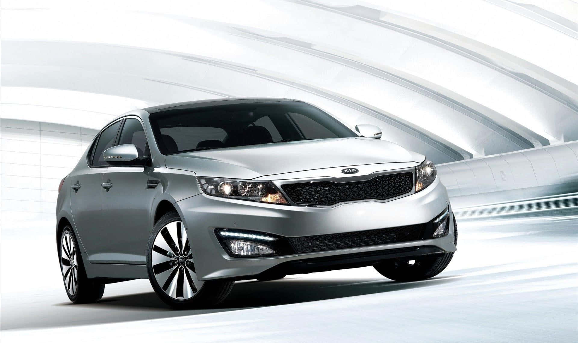 Sleek Silver Kia Optima Cruising On Scenic Highway Wallpaper