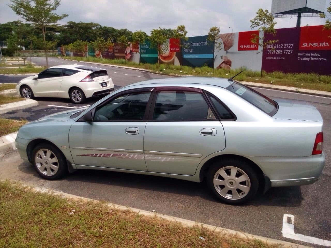 Sleek Silver Proton Waja On The Road Wallpaper