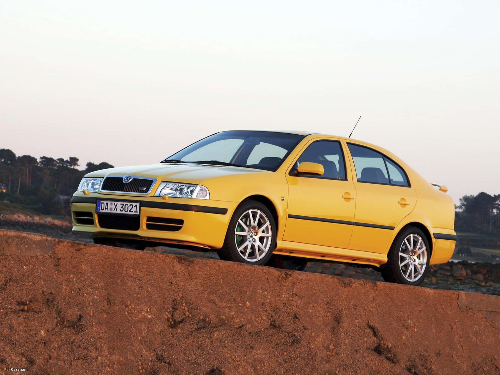 Sleek Silver Skoda Octavia Gliding Under Steel Grey Clouds Wallpaper