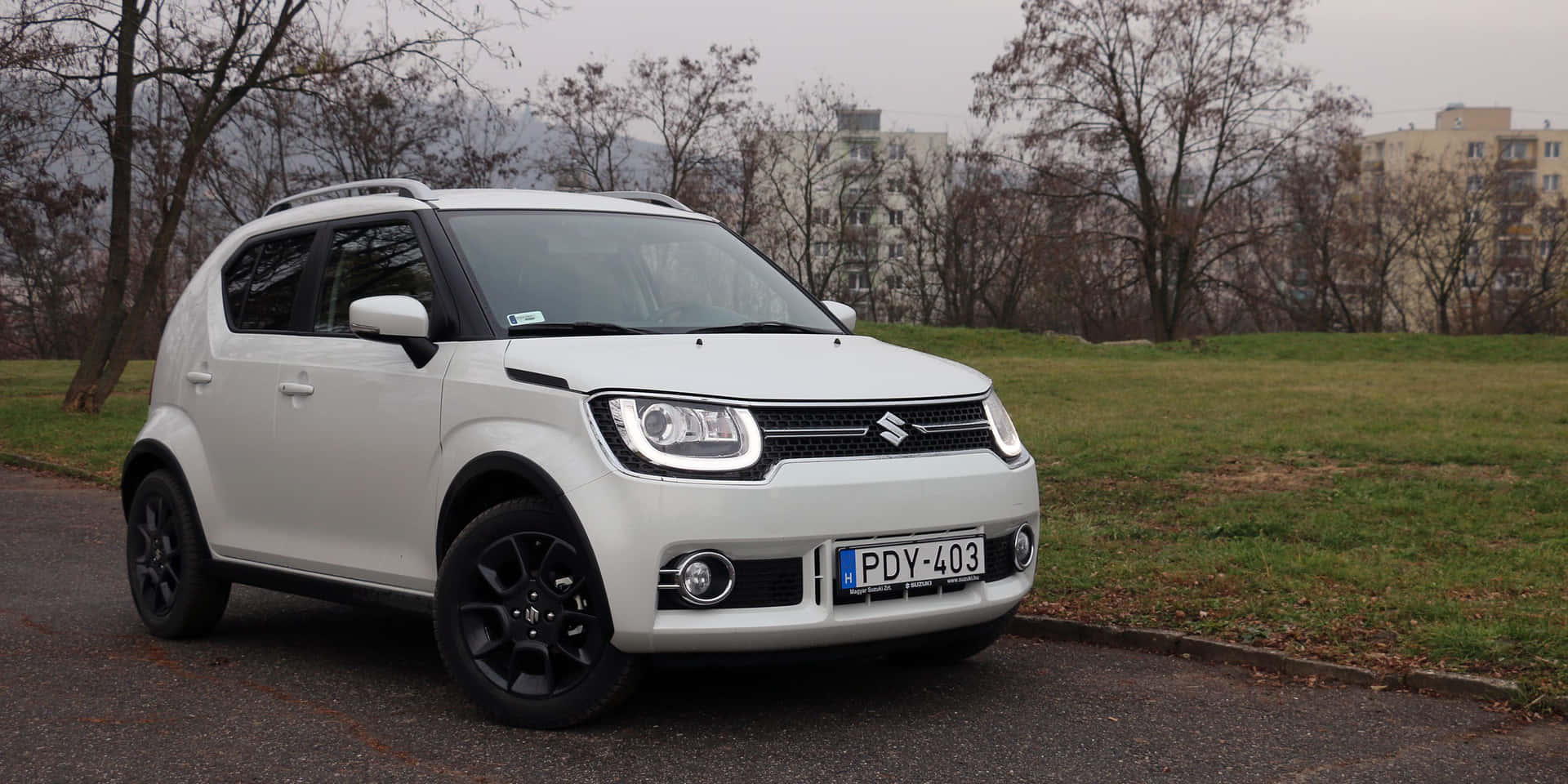 Sleek Silver Suzuki Ignis Gliding On A Wet Road Wallpaper