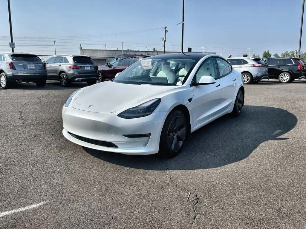 Sleek Tesla Model 3 Cruising Down The Highway Wallpaper