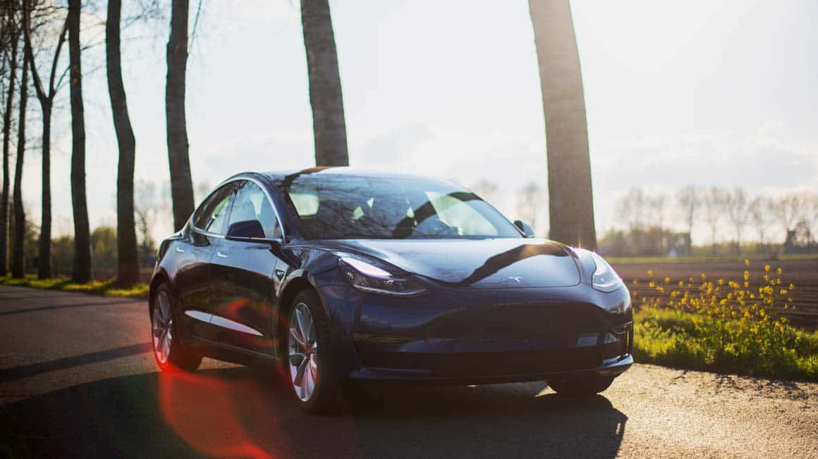 Sleek Tesla Model 3 Under The Night Sky Wallpaper