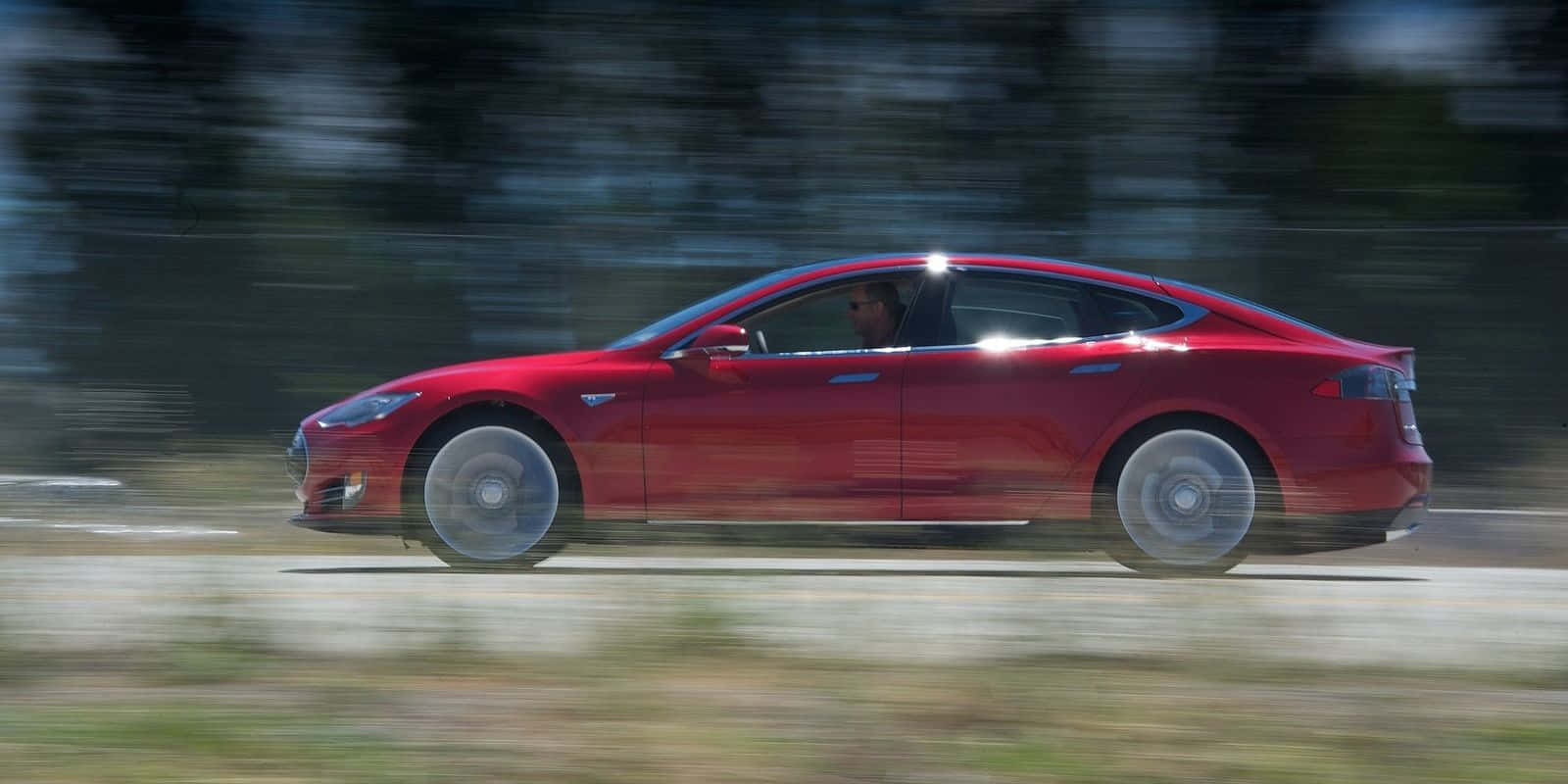 Slank Tesla Model S Som Akselererer På Motorveien Bakgrunnsbildet