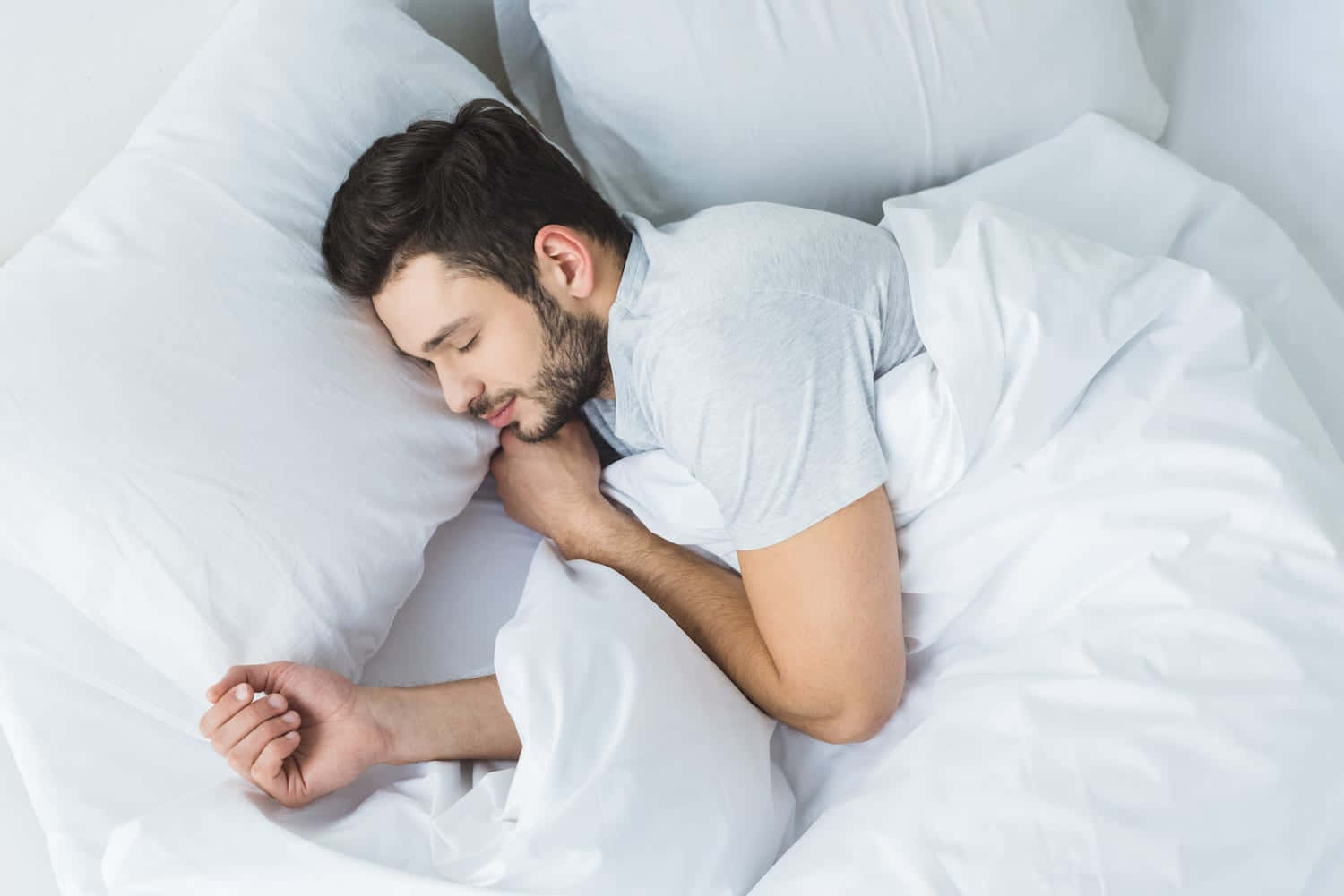 Man Sleeping In Bed With White Sheets