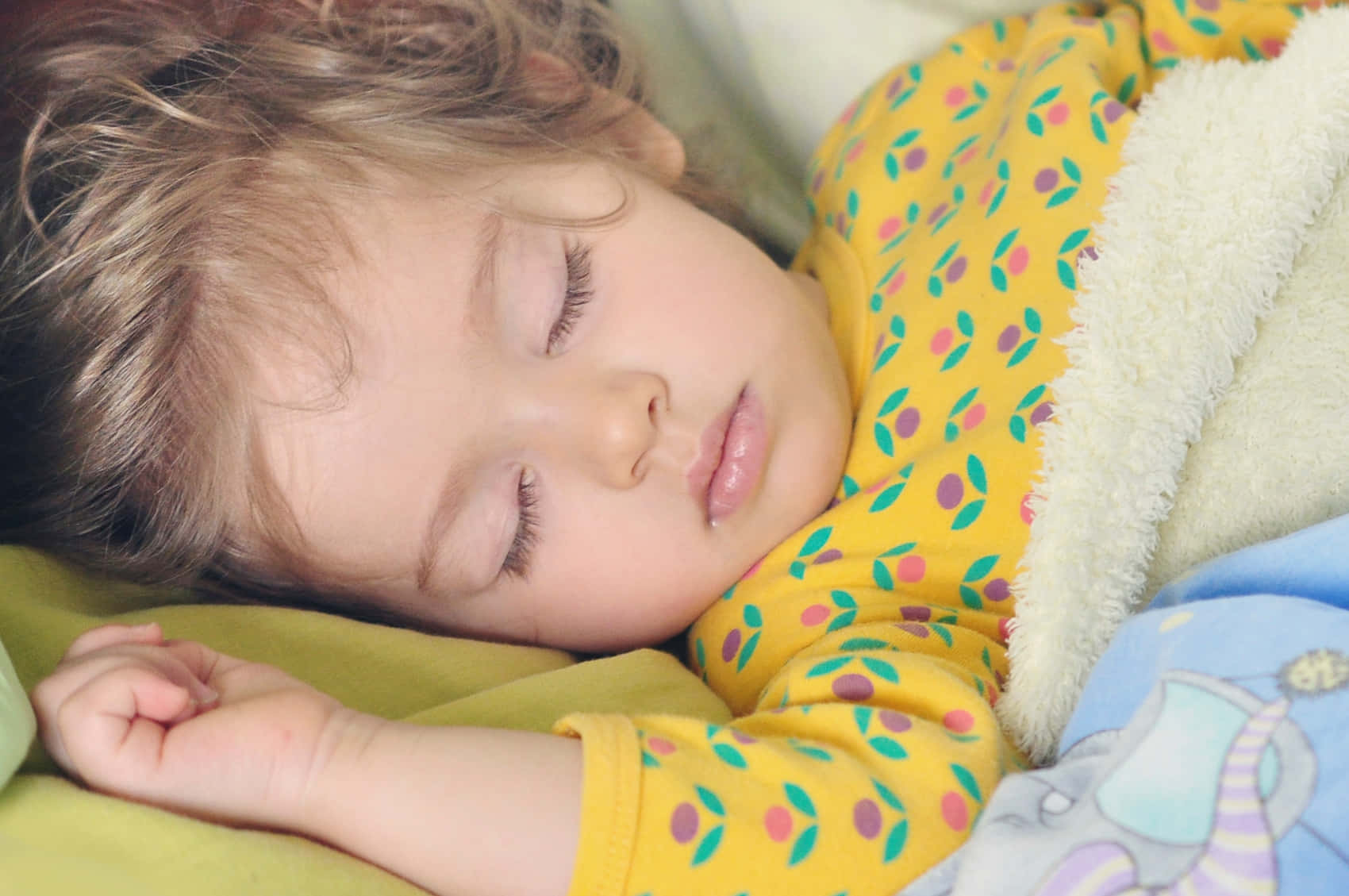 A Child Sleeping In A Bed