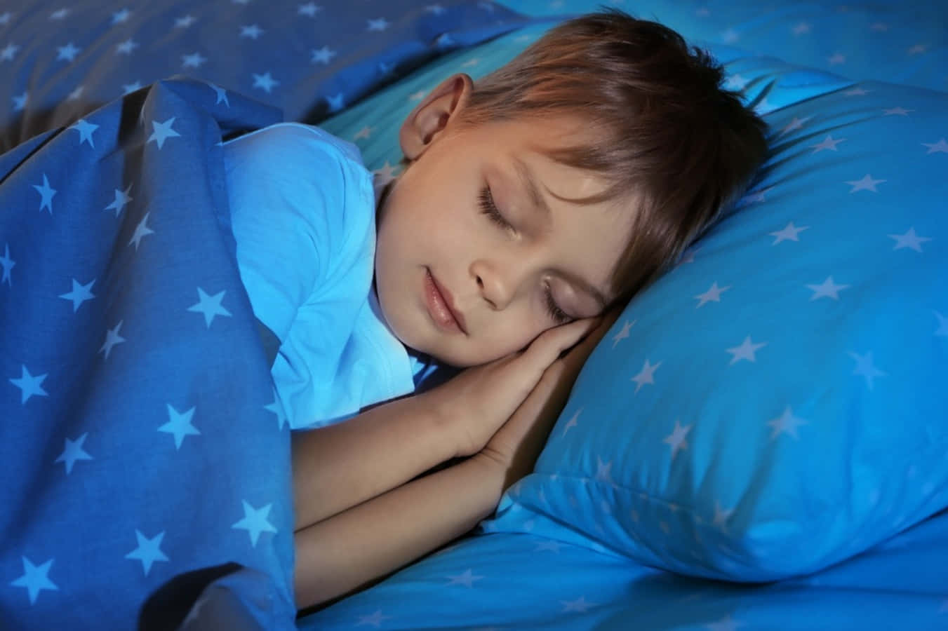Einjunger Junge Schläft In Einer Blauen Decke.