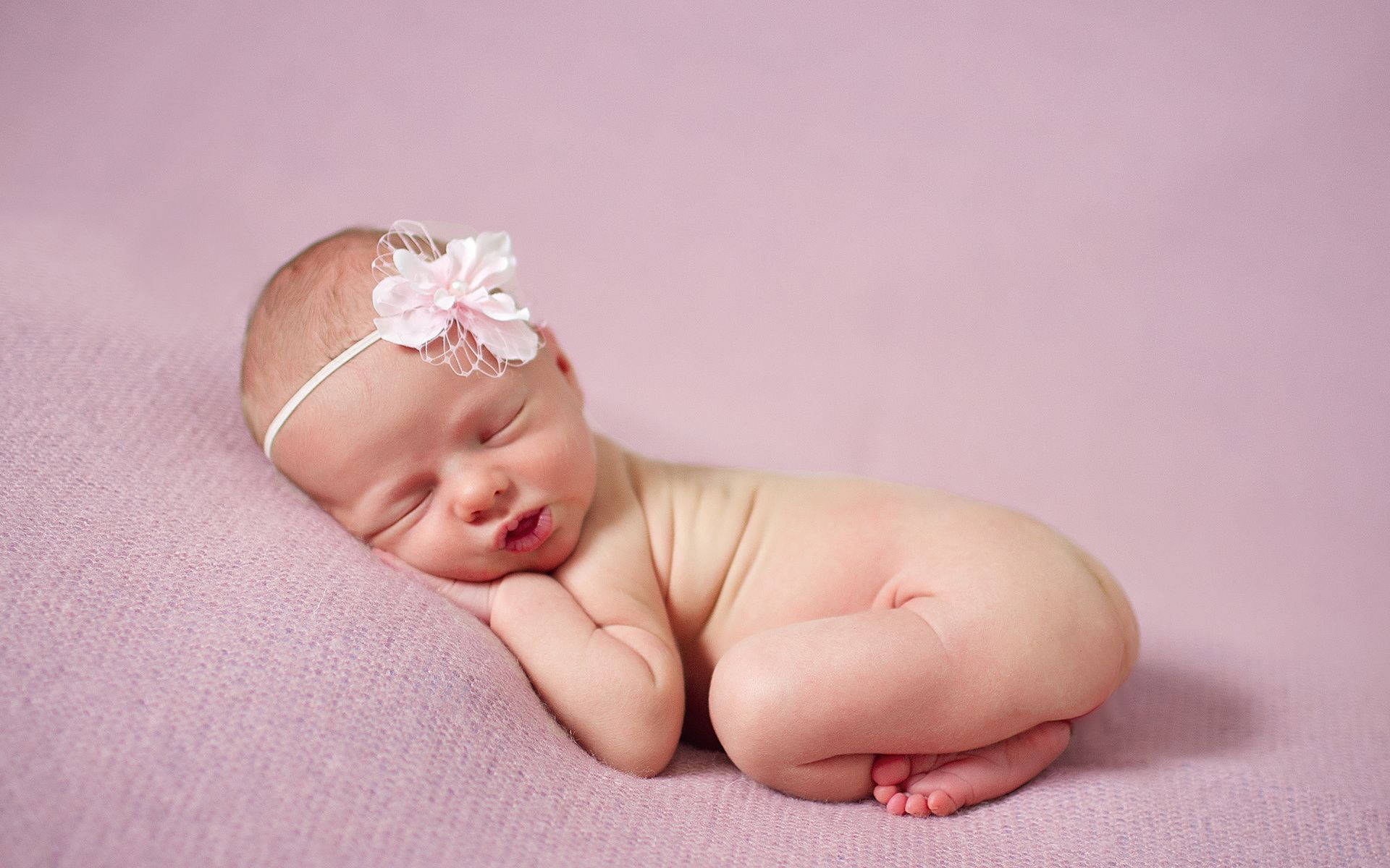 Baby taking a peaceful nap in a flower headband Wallpaper