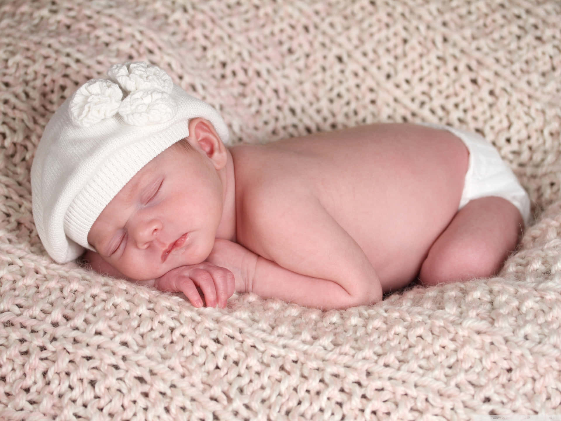 Sleeping New Born Baby With A White Cap Wallpaper