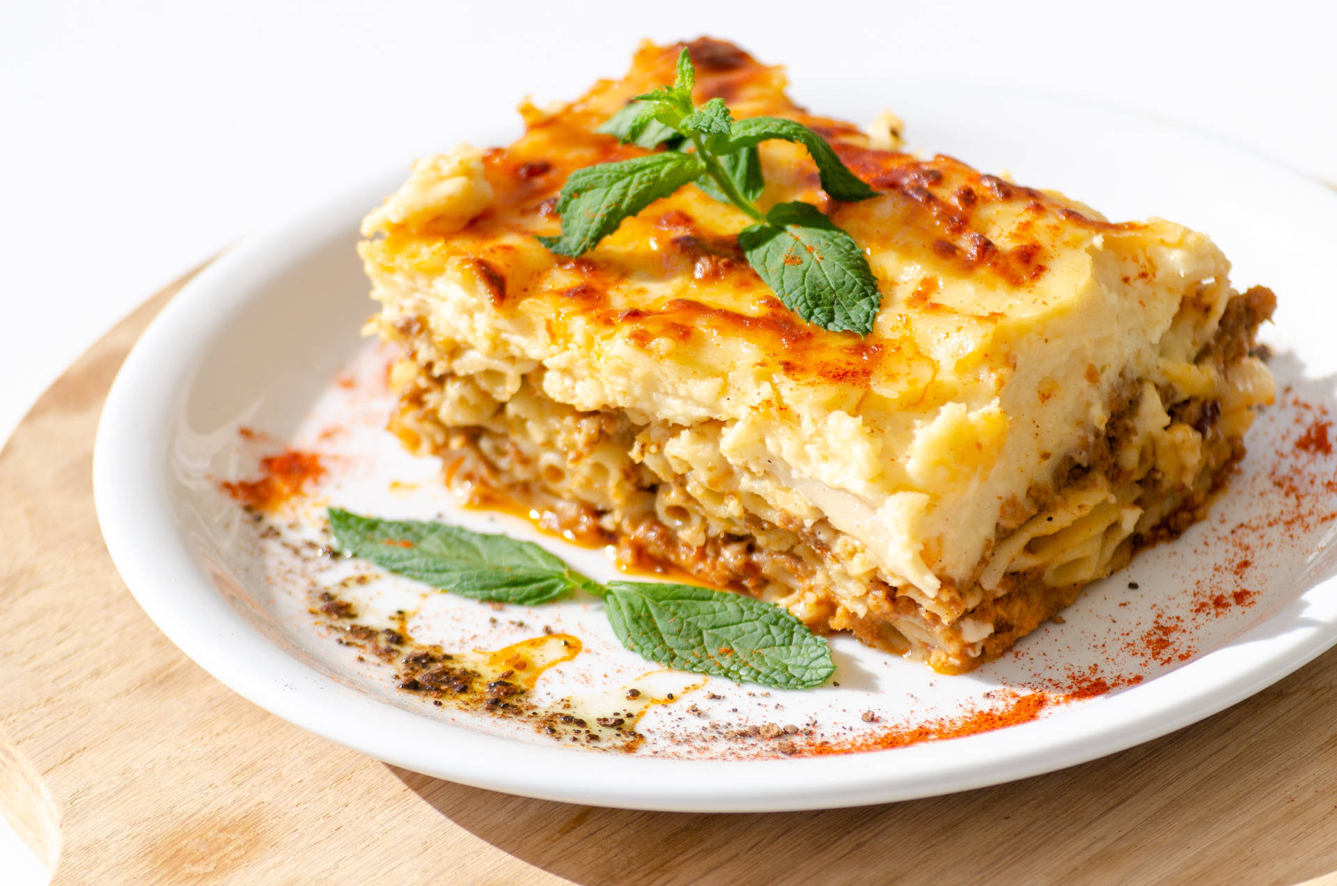 Delicious Slice of Authentic Moussaka Garnished with Basil Wallpaper