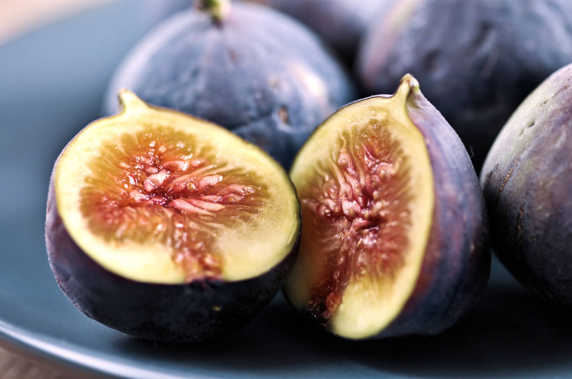 Sliced Figs Adorning a Blue Plate Wallpaper