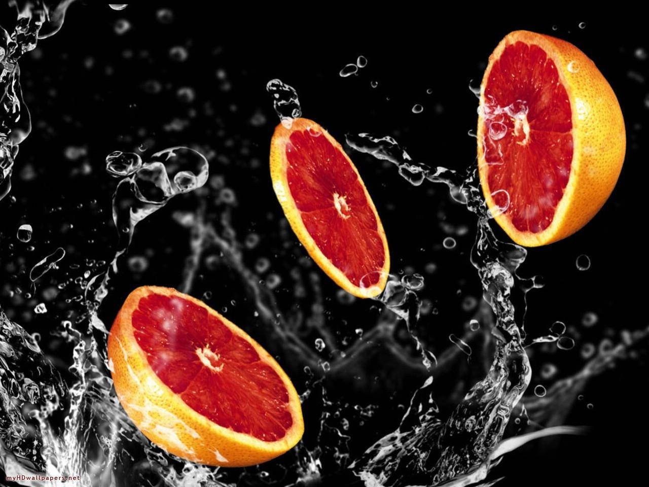 Skivet grapefrugter med vandsplash – til din skrivebord. Wallpaper