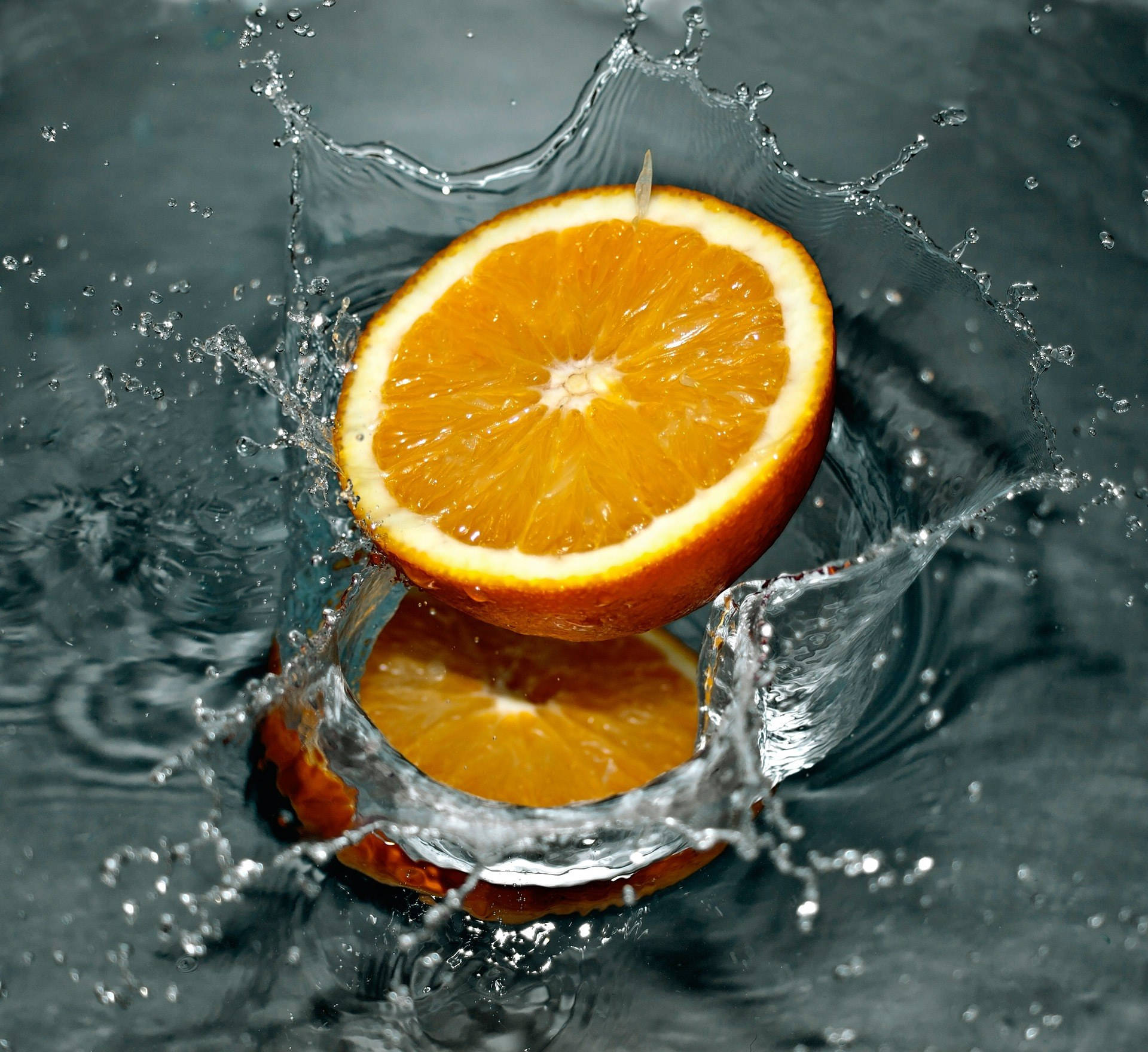 Sliced Orange Falling In The Water Wallpaper