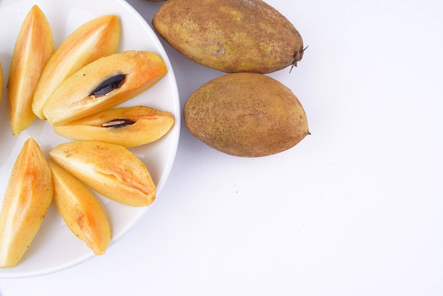 Slices Of Sapodilla Fruits On Plate Wallpaper