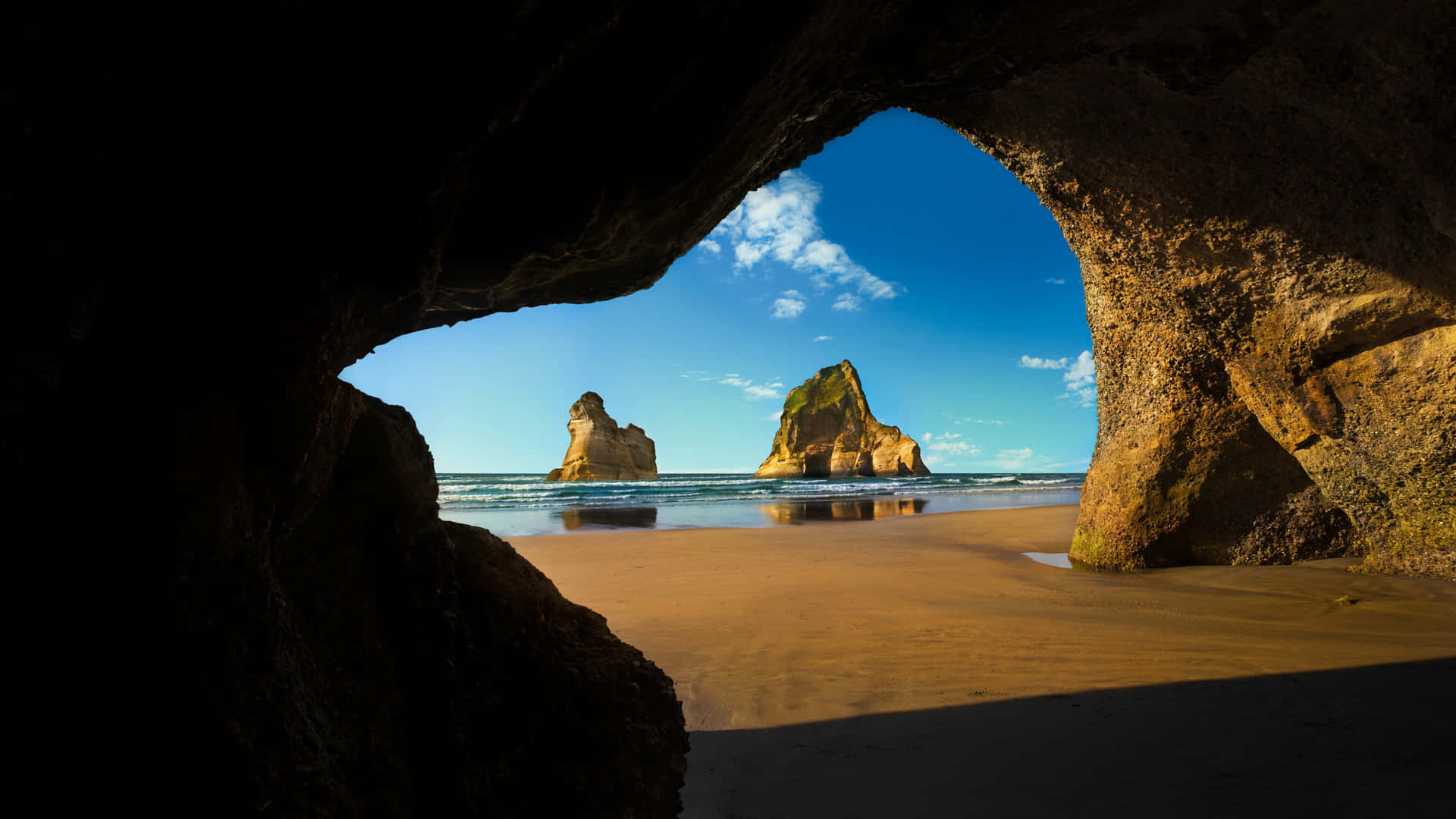 A View Of A Beach From A Cave