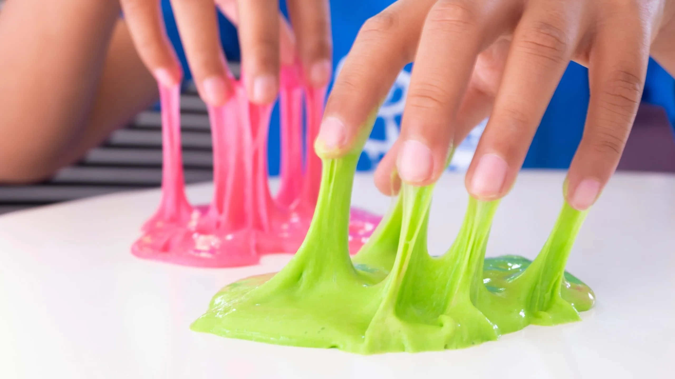 A Person Is Making A Colorful Slime With Her Hands