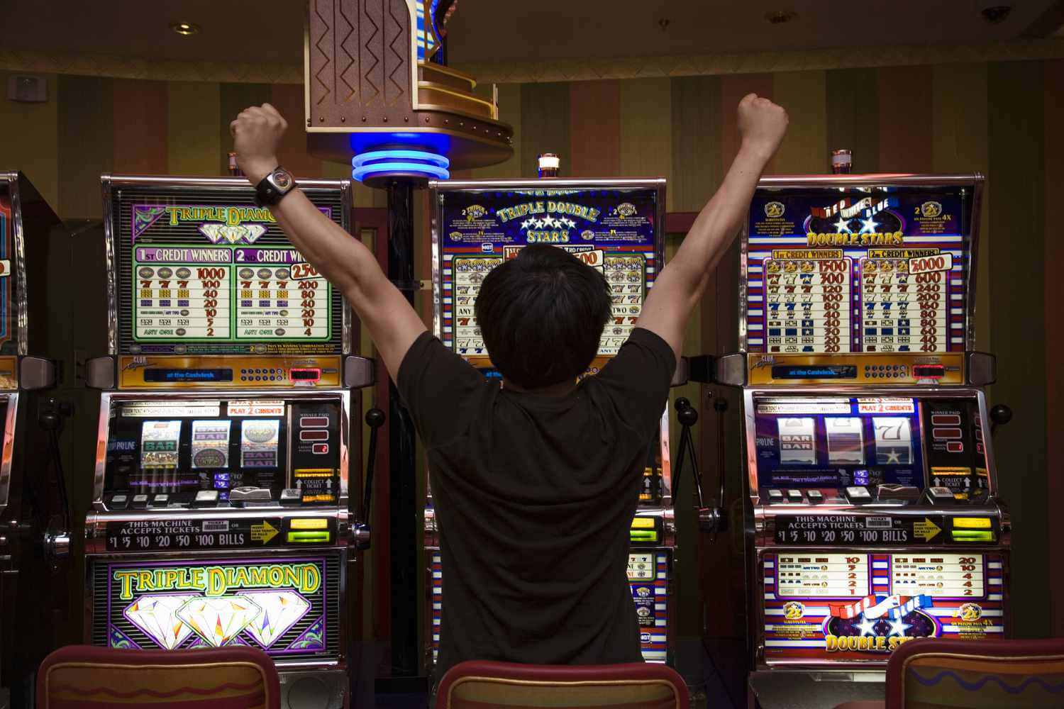 A Man Is Standing In Front Of A Slot Machine