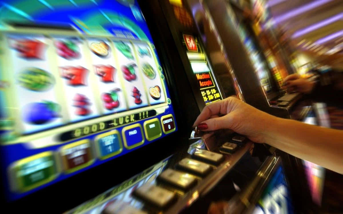 A Woman Is Playing A Slot Machine In A Casino