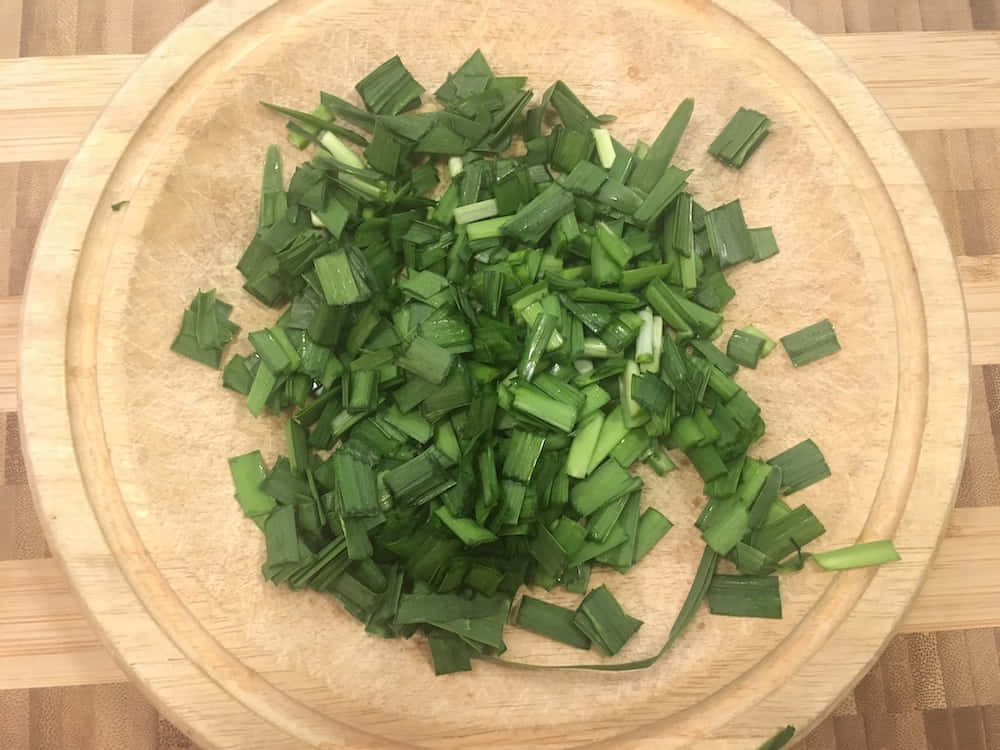 Small Cuts Of Green Chives On Wooden Bowl Wallpaper