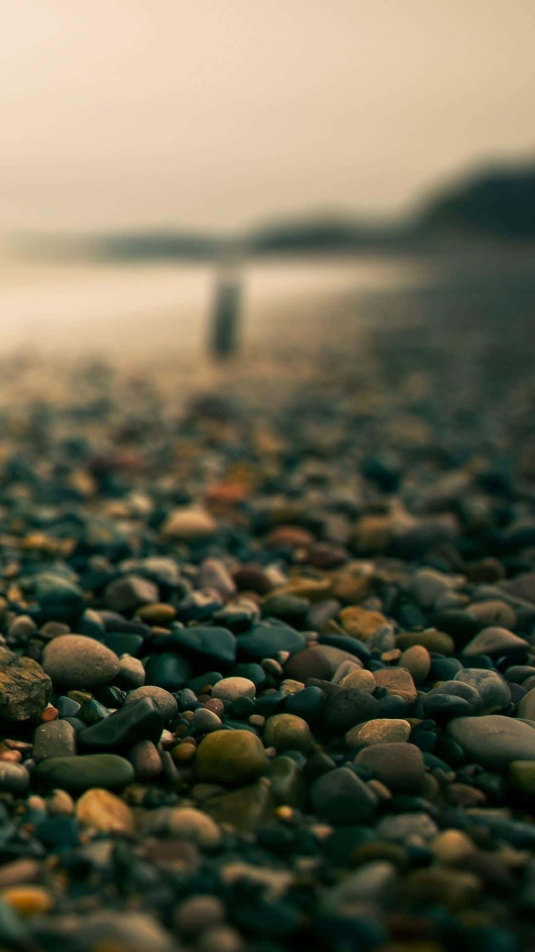 En strand med sten og klipper på det. Wallpaper