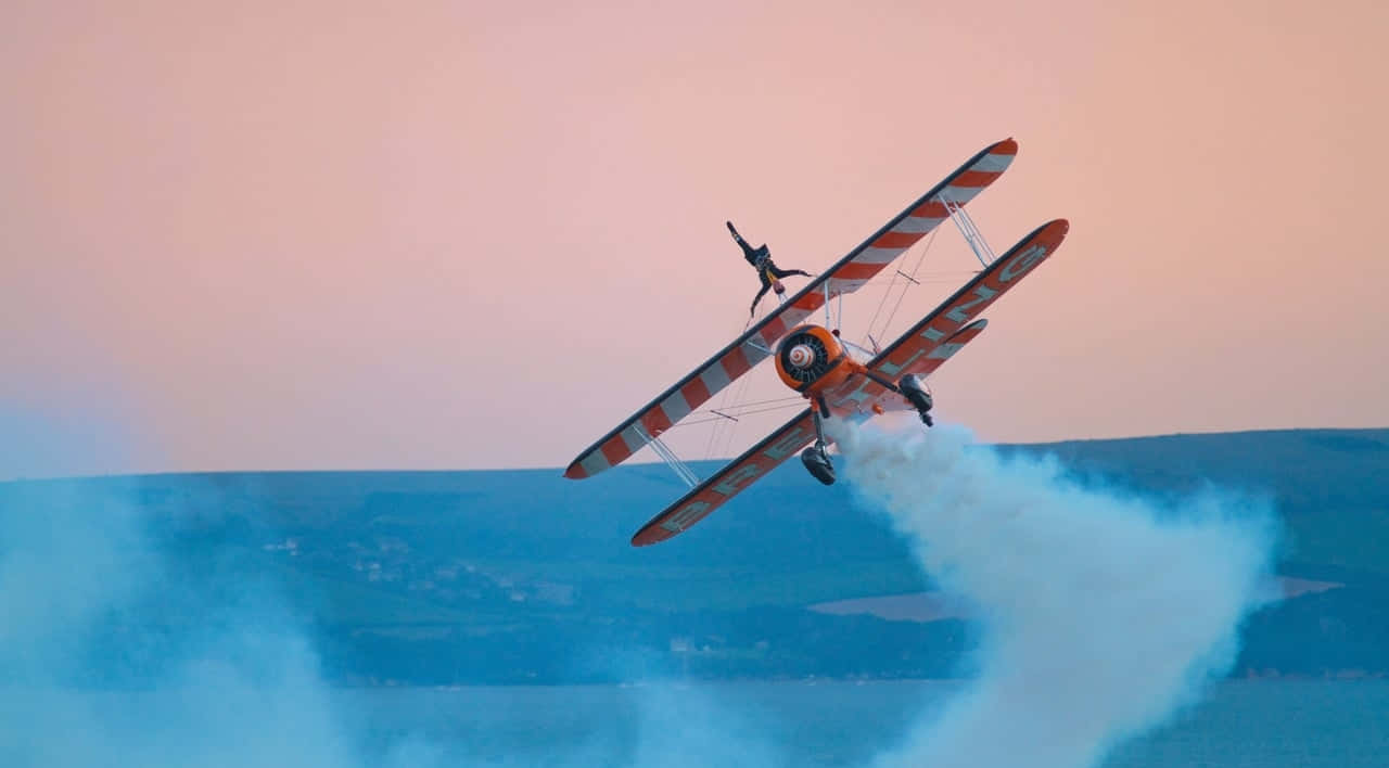 Hintergrundmit Orange Gestreiftem Fliegendem Stunt-kleinflugzeug