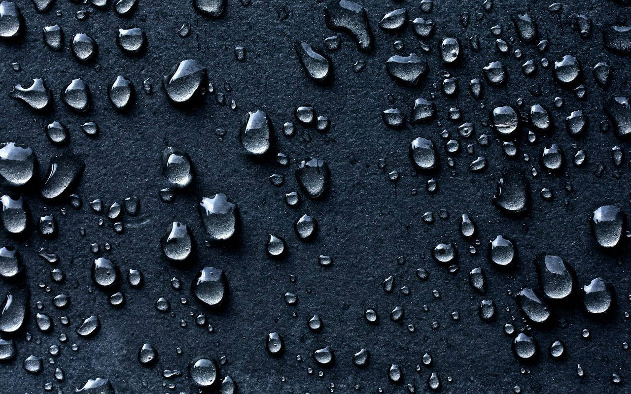 Pequeñasgotas De Lluvia En Una Superficie Negra. Fondo de pantalla