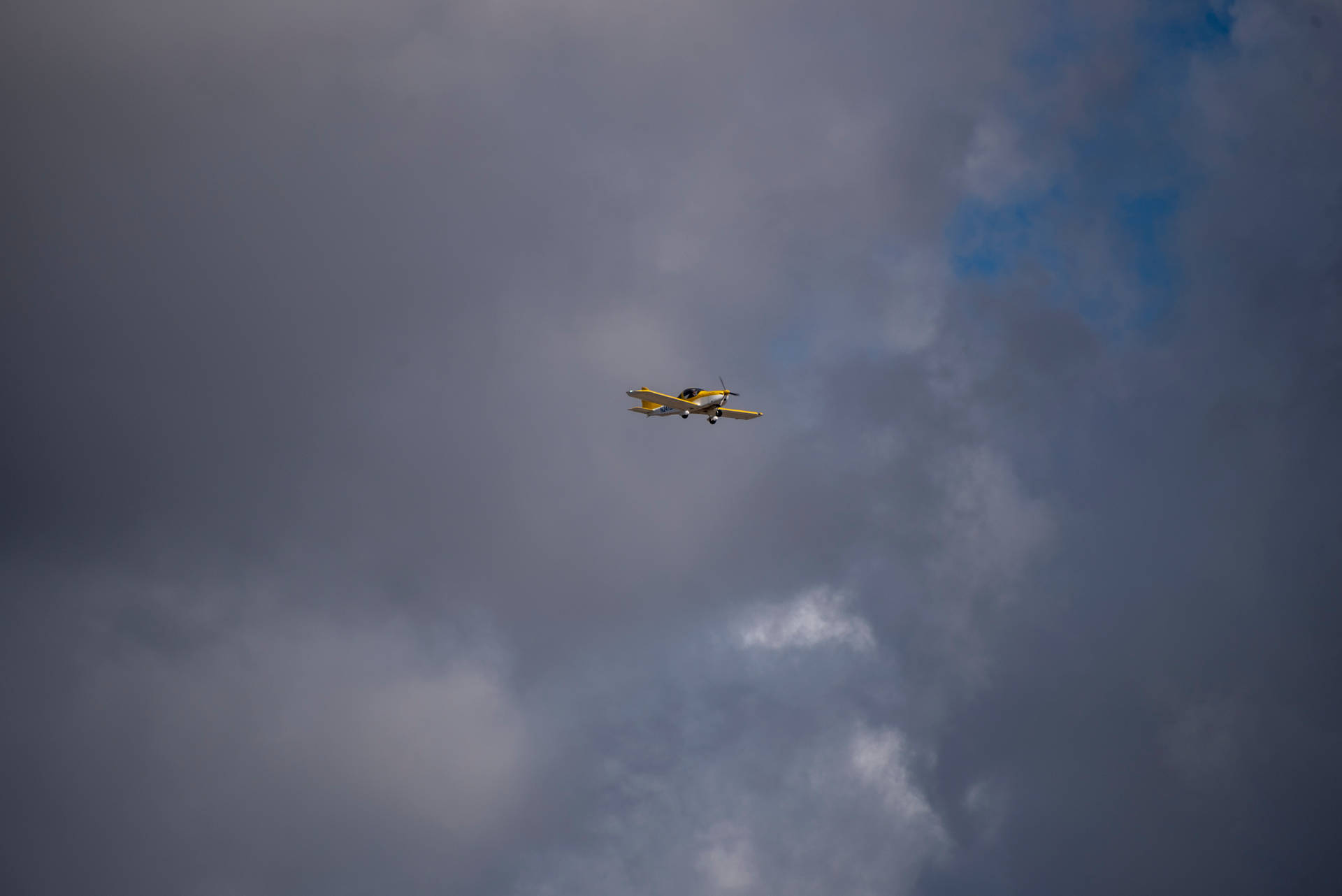 Kleinesgelbes Flugzeug Am Himmel Wallpaper
