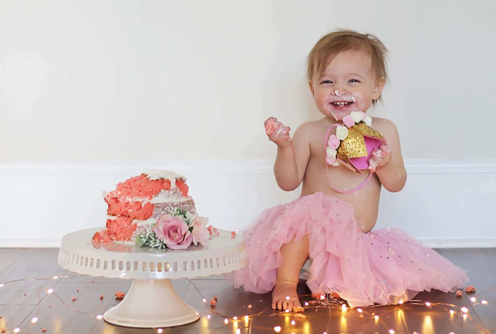 A Baby Girl Sitting On The Floor With A Cake