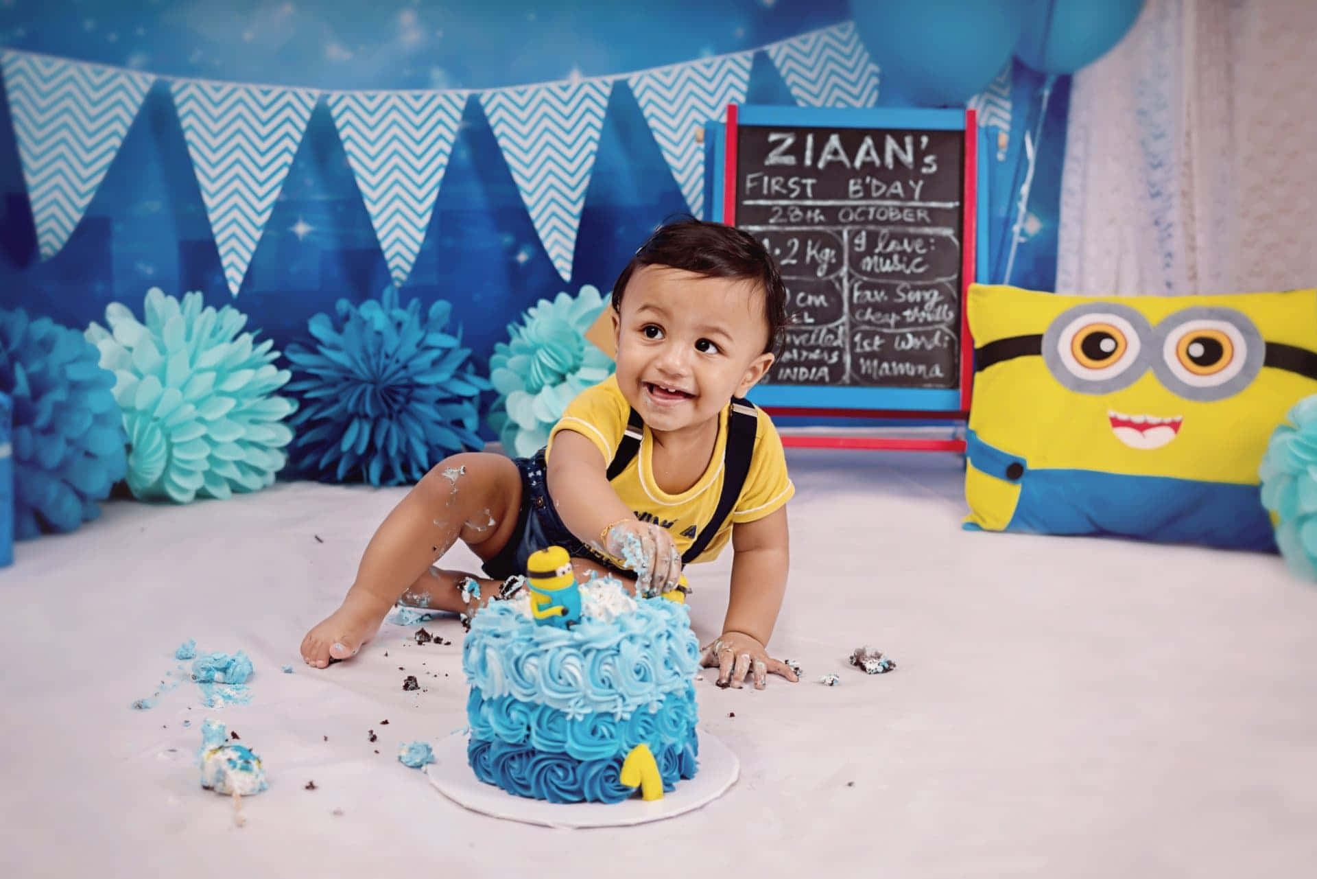 A Baby Boy Is Playing With A Blue Cake