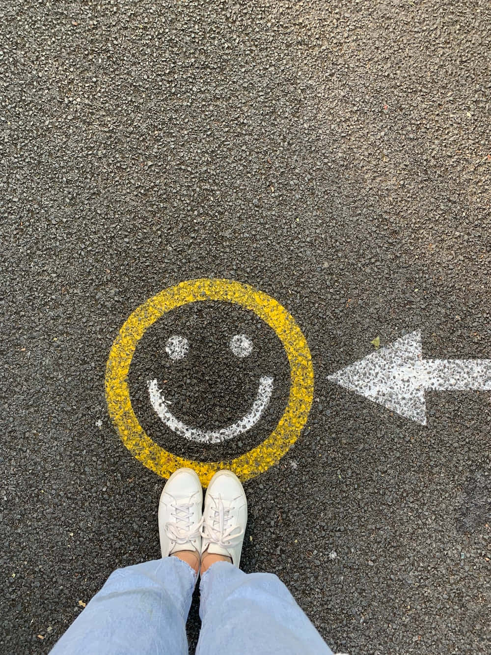 Unapersona In Piedi Su Una Strada Con Un Sorriso Disegnato Sopra
